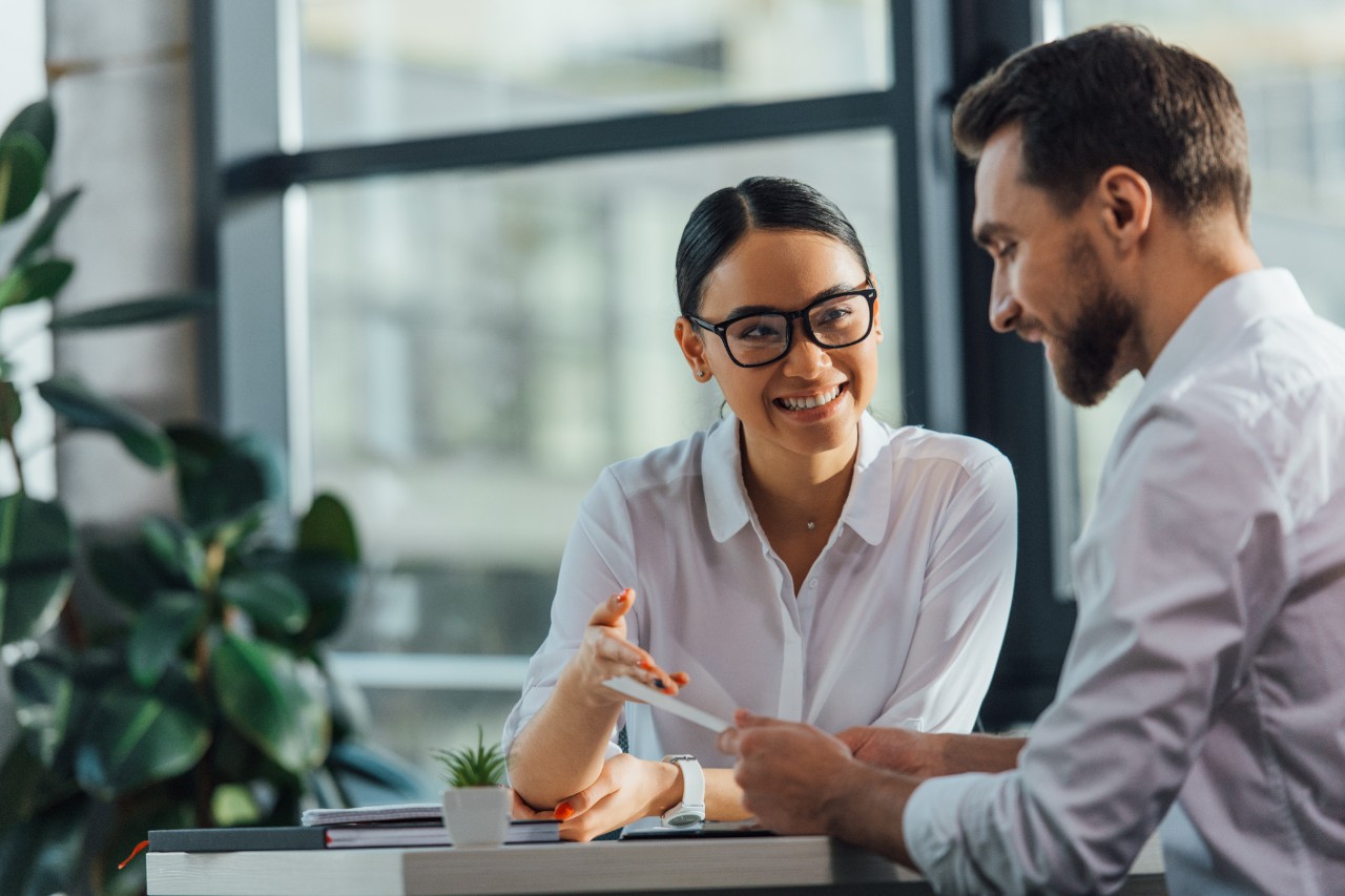 female asian translator working working with smiling businesswoman