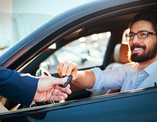 Homme reçoit clefs pour nouvelle voiture du vendeur