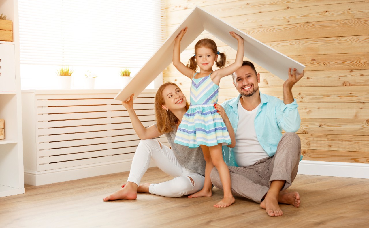 concept housing a young family. Mother father and child in new house with a roof